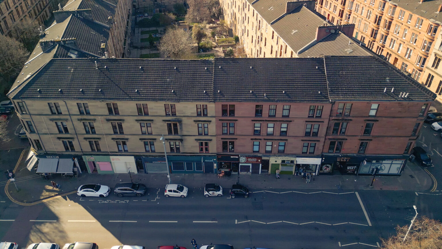 Hyndland Street, Partick, Glasgow aerial view showing cars roofs of blonde and red sandstone tenements on a sunny day